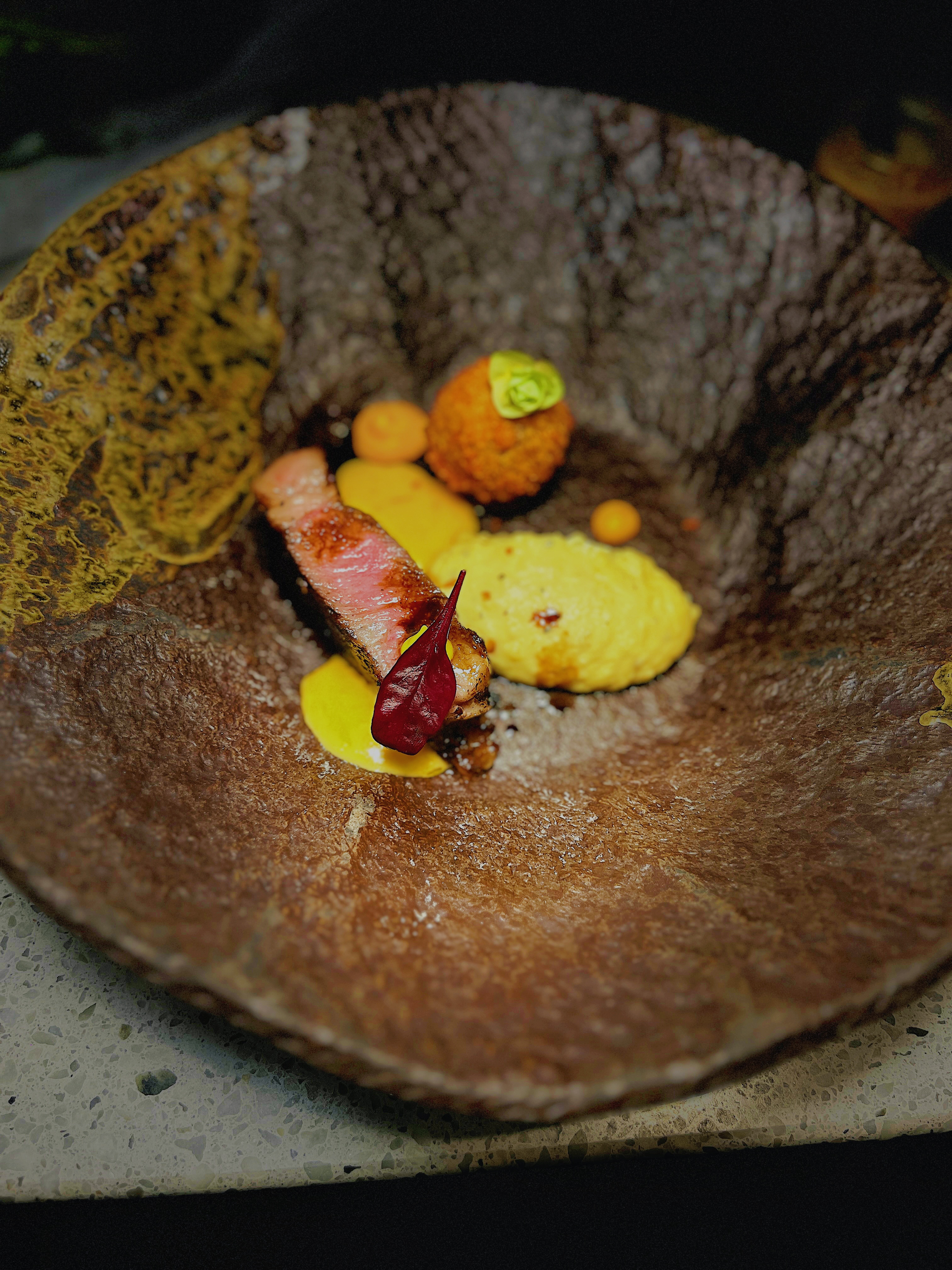 Plated meat dish served in a textured bowl