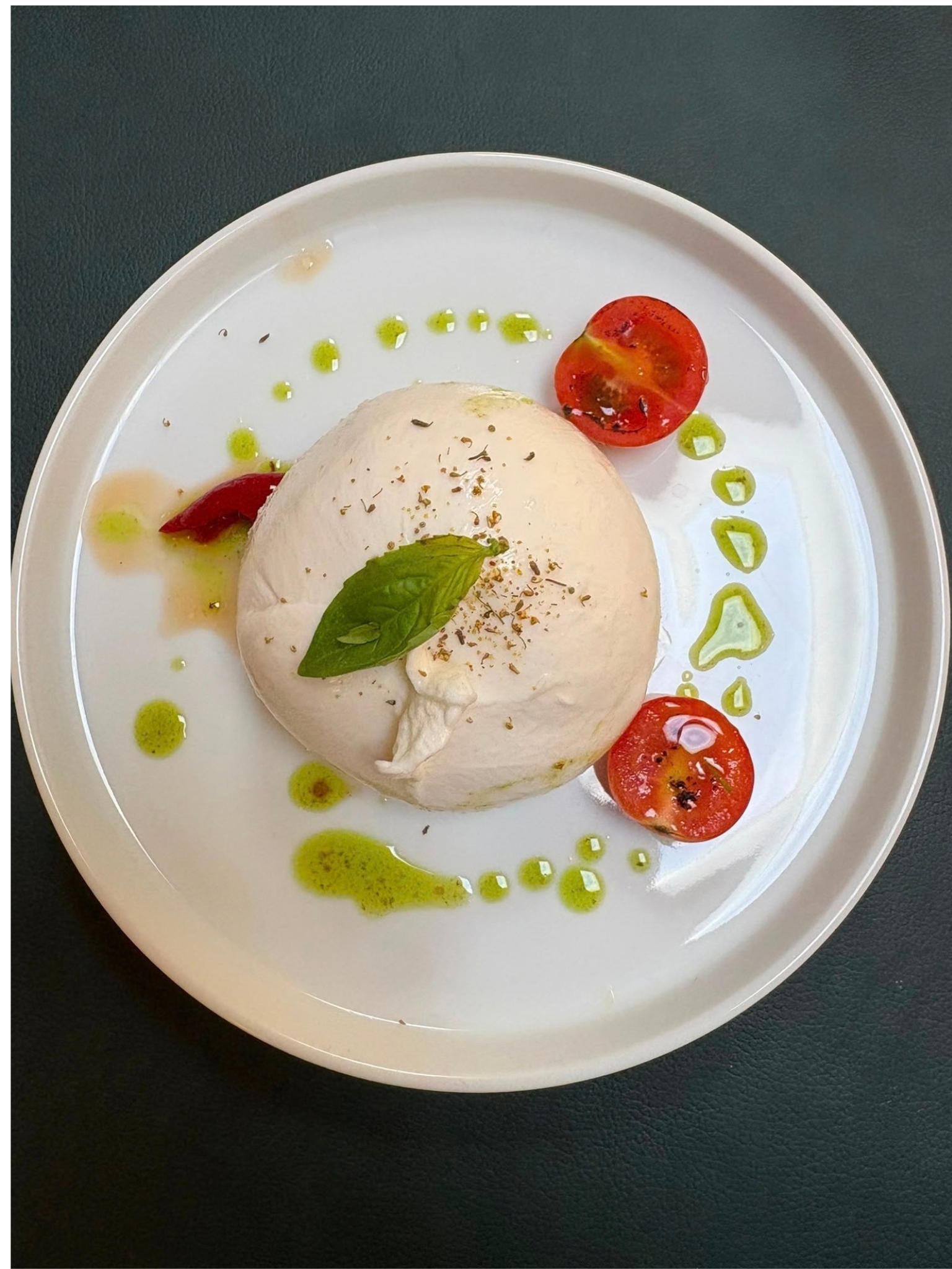 Burrata with charred cherry tomatoes and basil oil