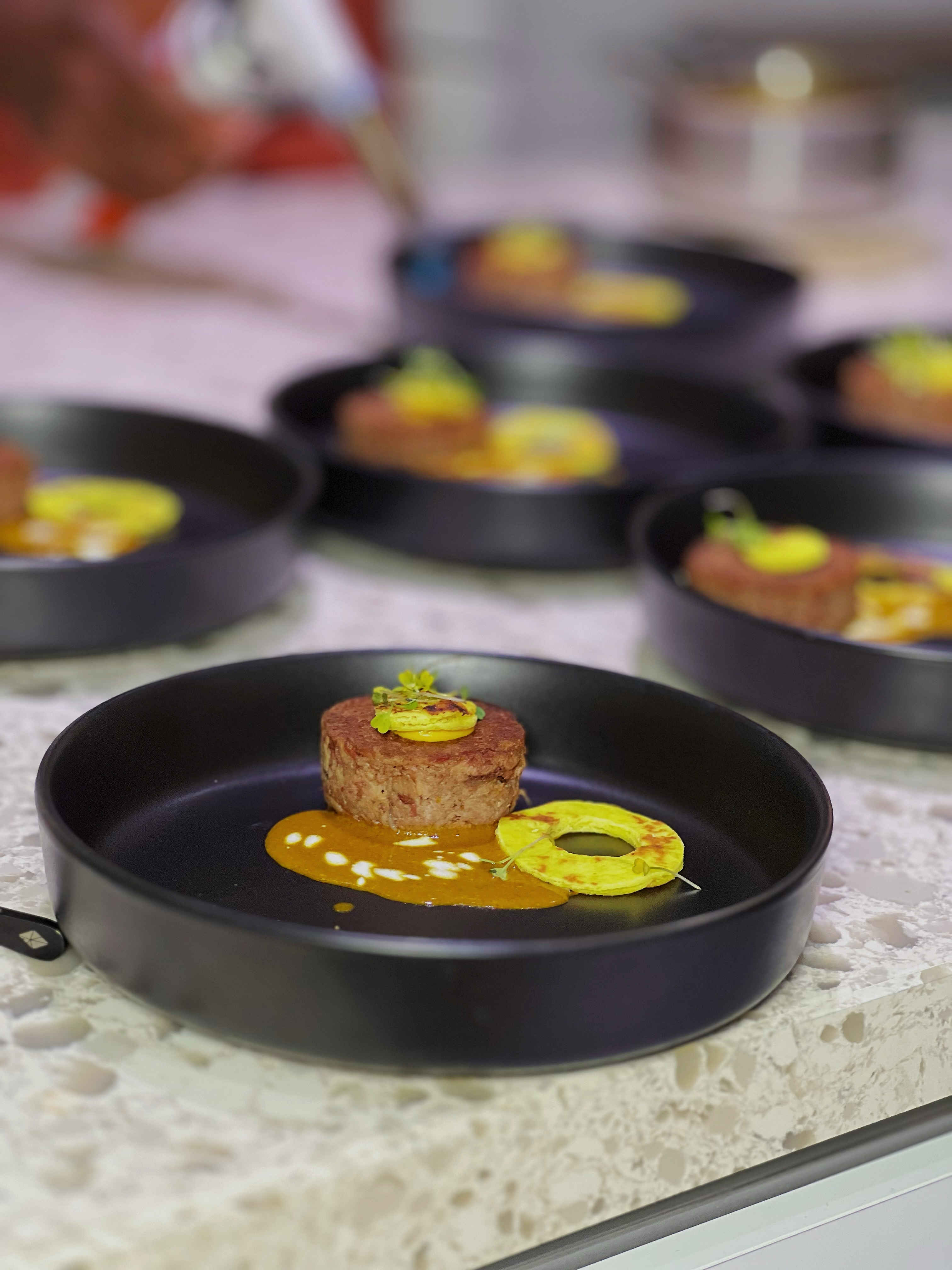 Plated meat with sauce and a golden ring