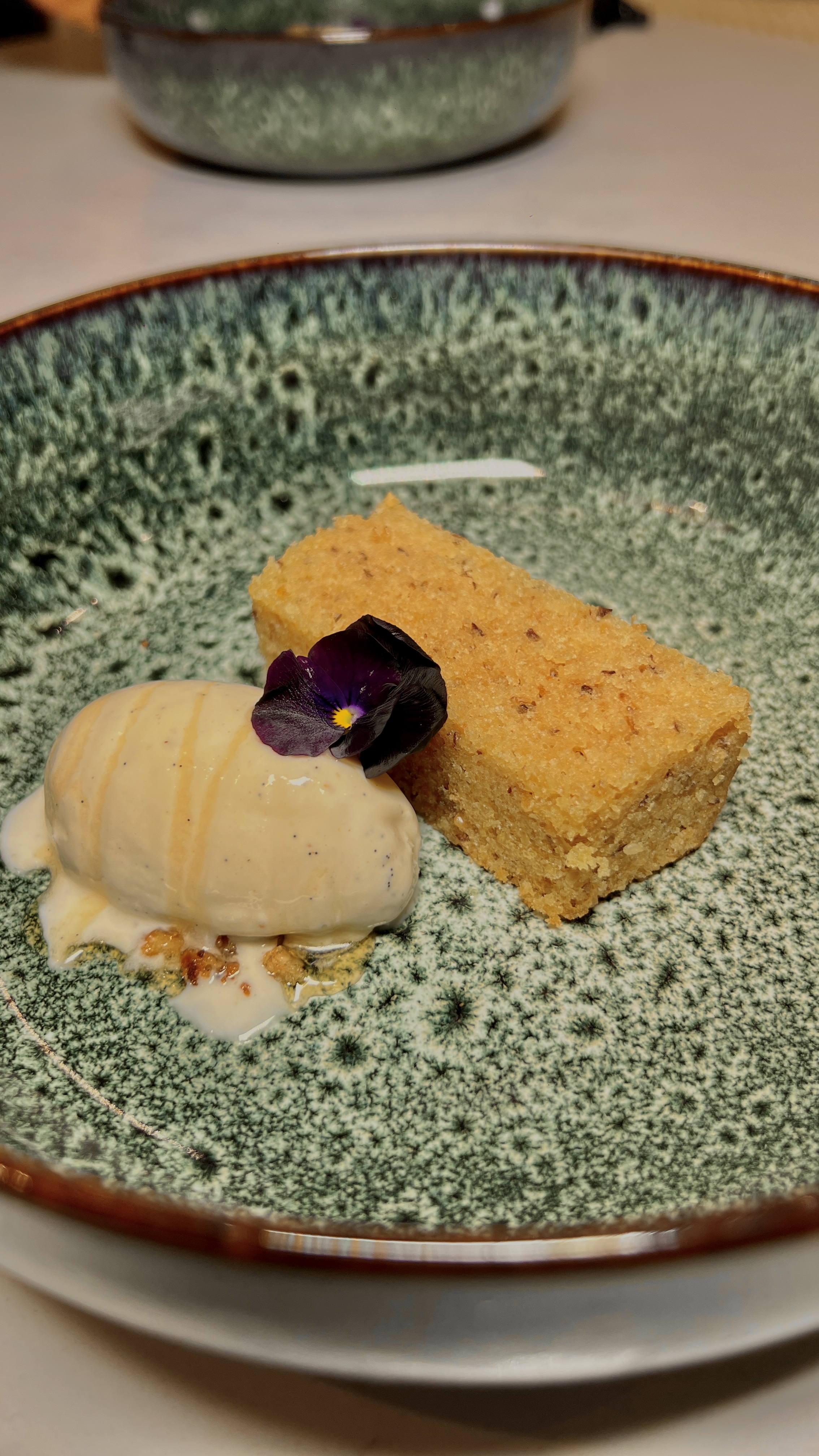 Polenta cake with vanilla ice cream and edible pansy